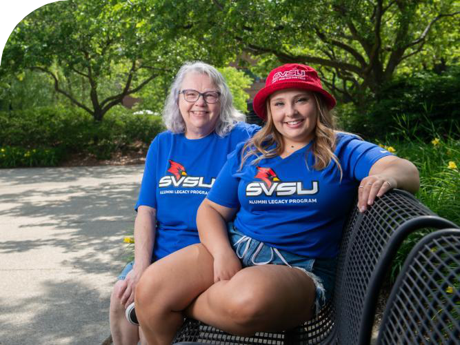 SVSU legacy student and alumni sitting together on campus